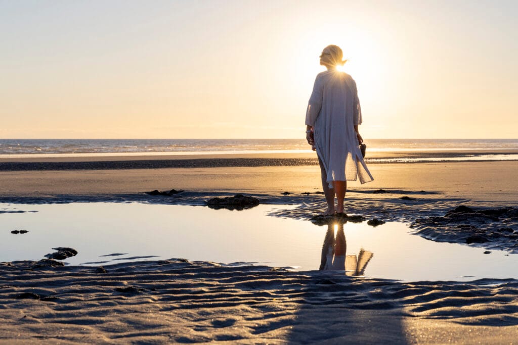 mature woman walks along empty beach